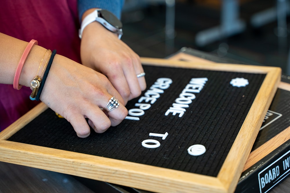 a person's hands on a black board