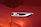A close-up of a shiny, metallic badge with the text 'GT Line' on a surface with a glossy red paint finish. The badge is bordered by a sleek silver trim.