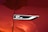 A close-up of a shiny, metallic badge with the text 'GT Line' on a surface with a glossy red paint finish. The badge is bordered by a sleek silver trim.