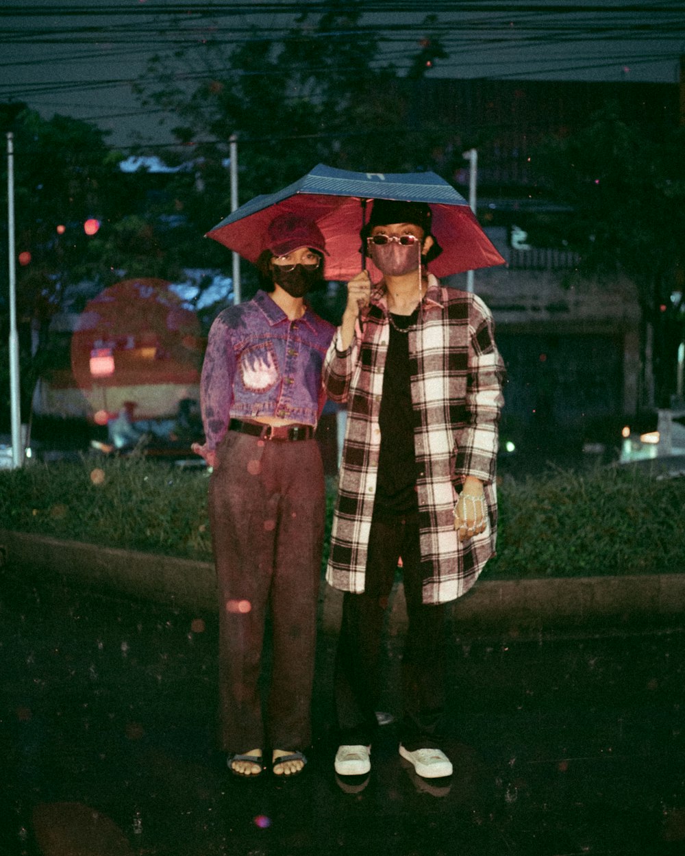 a couple of men stand under an umbrella