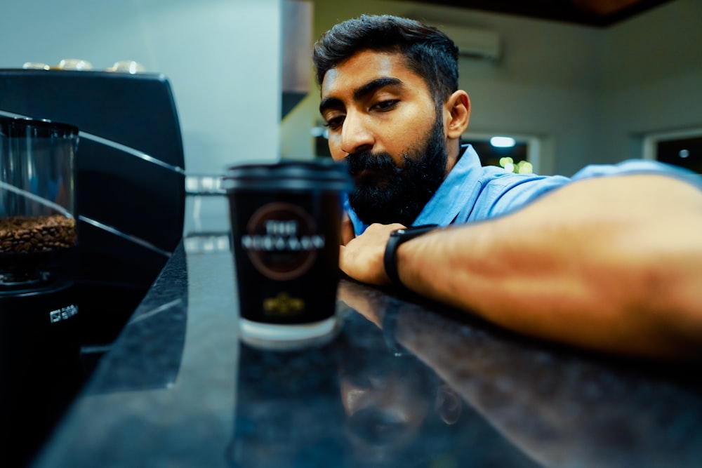 a man with a beard holding a cup of coffee