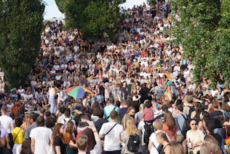 An outdoor cultural event with people gathered near the monumental staircase in the park.