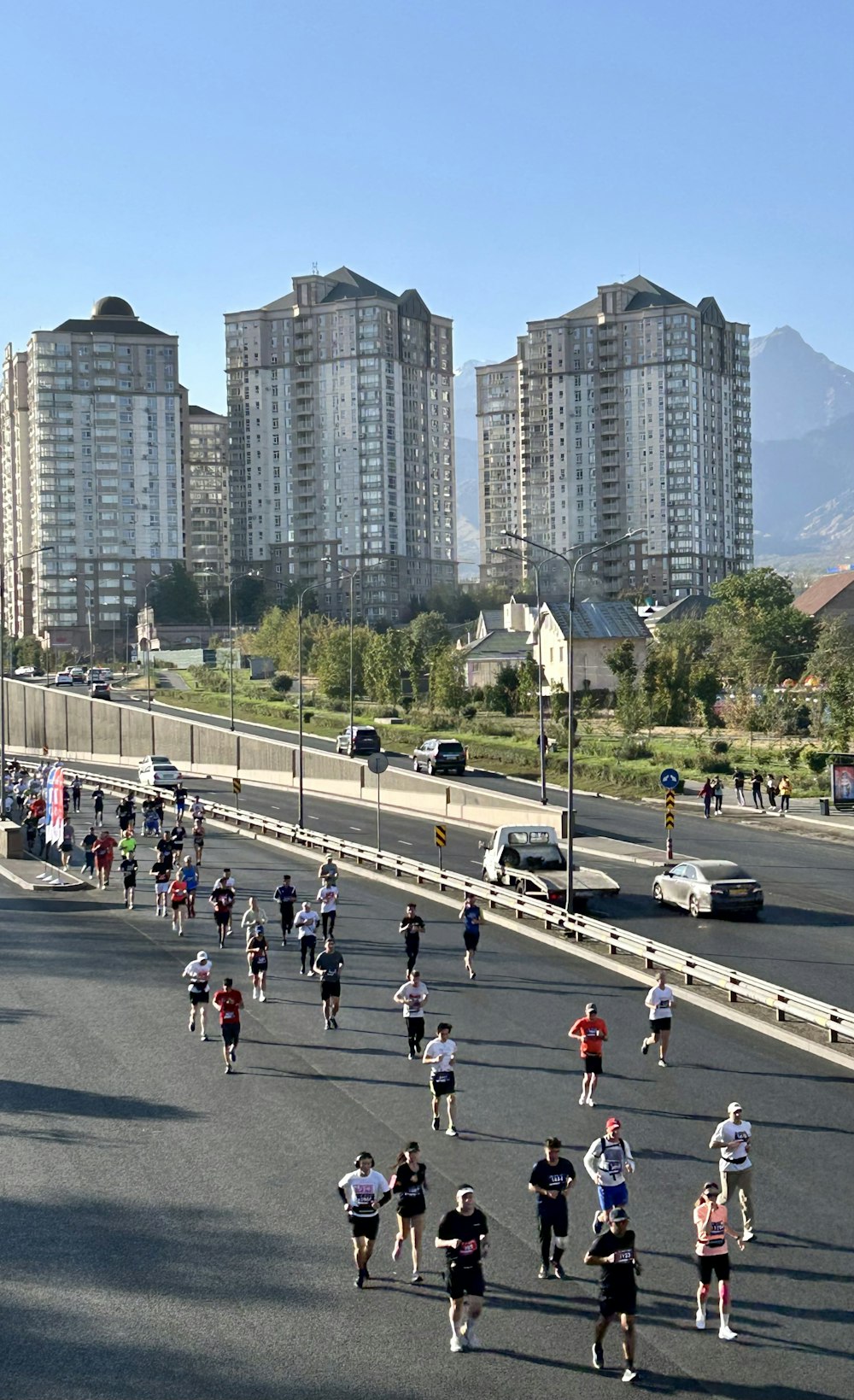 a group of people running on a street in front of tall buildings