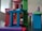 A collection of colorful wooden blocks is stacked in a playful and abstract manner, forming a miniature structure. The blocks vary in shape and color, creating a dynamic and vibrant arrangement.