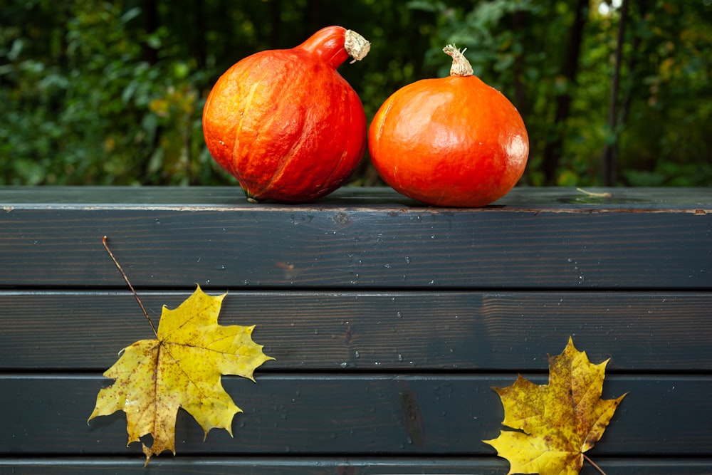 two red tomatoes on a wooden surface