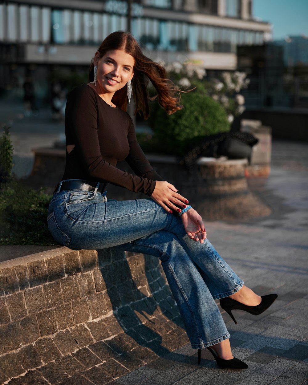 a woman sitting on a brick wall