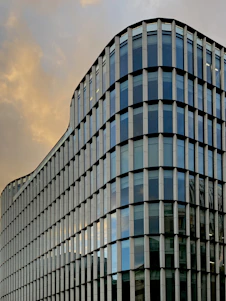 A sleek, contemporary building with large glass windows reflecting a vibrant city skyline.