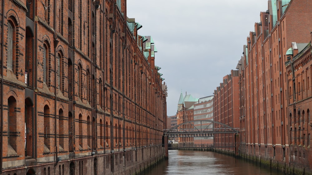 a bridge over a canal between two brick buildings