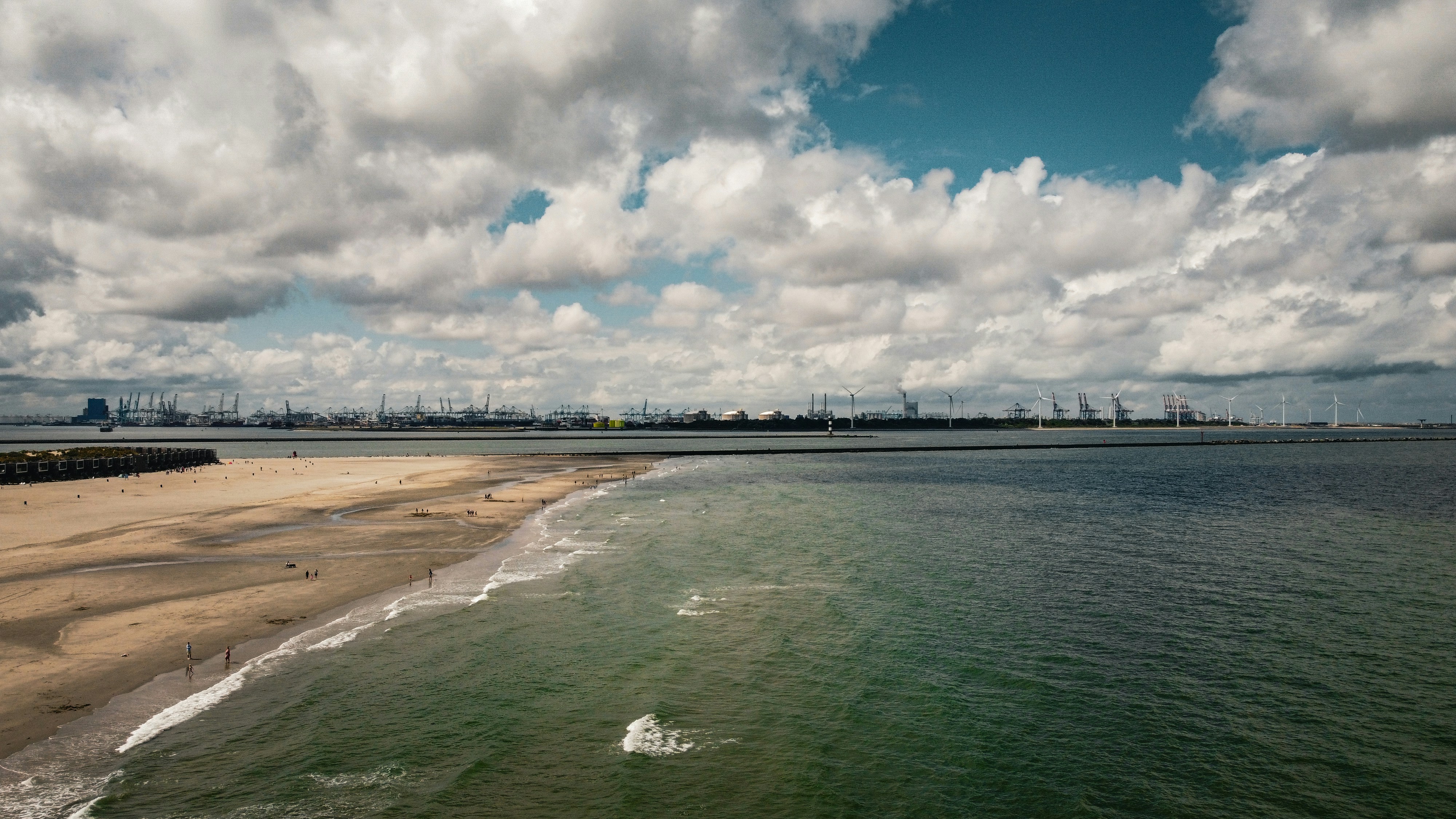 a beach with a body of water and a city in the background