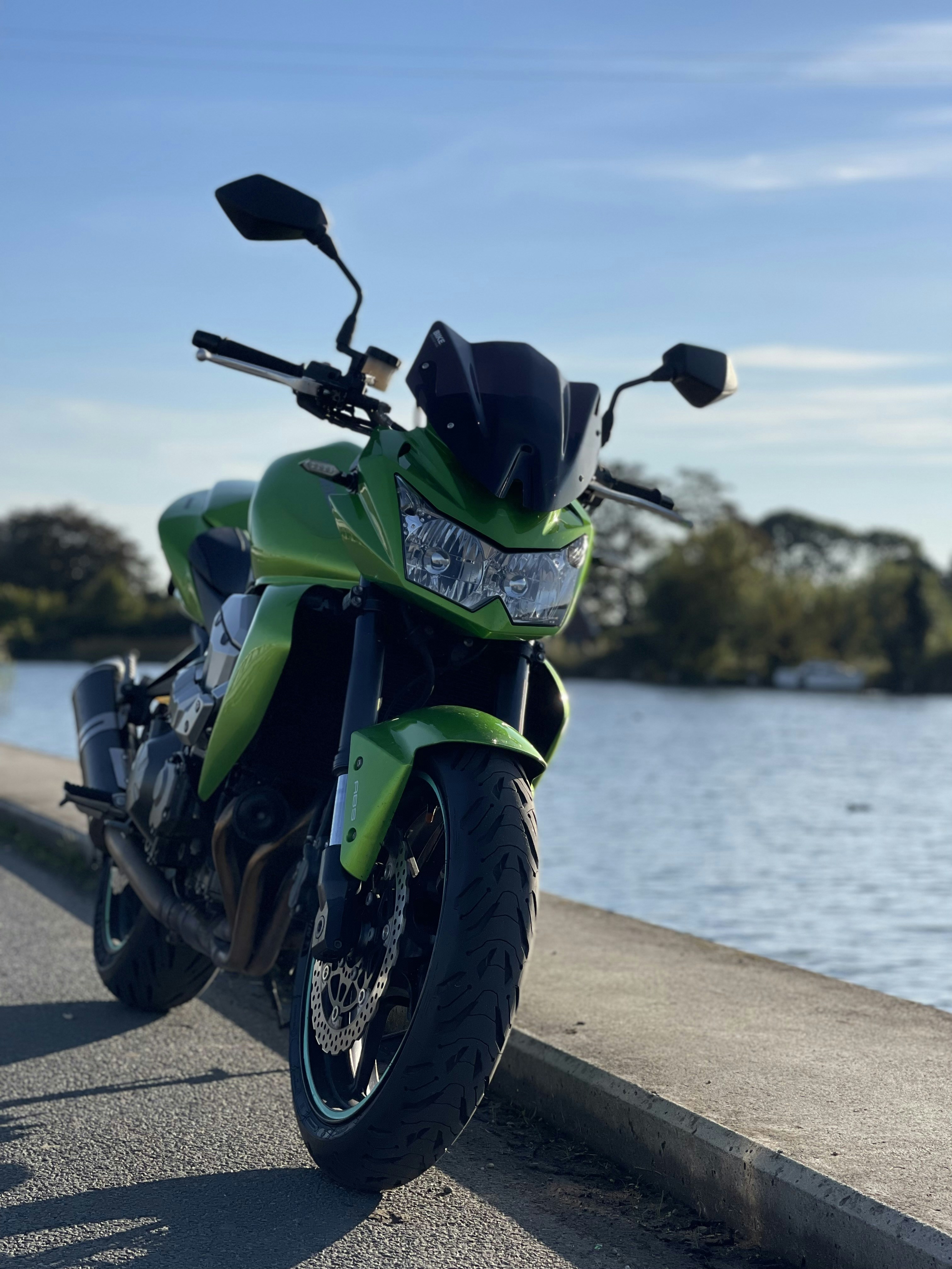 a green motorcycle parked on a sidewalk