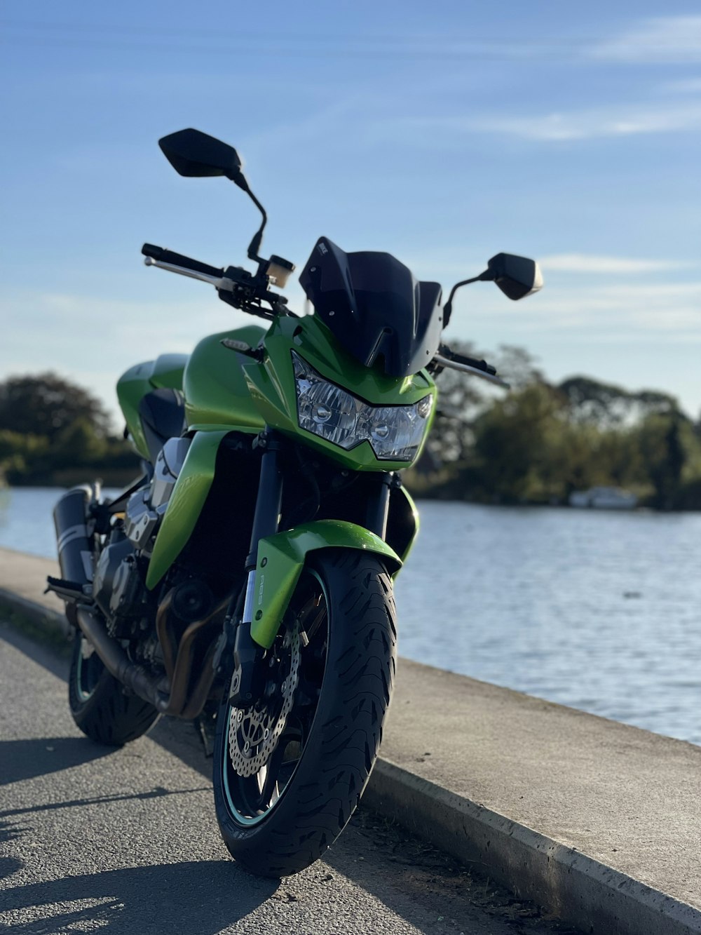 a green motorcycle parked on a sidewalk
