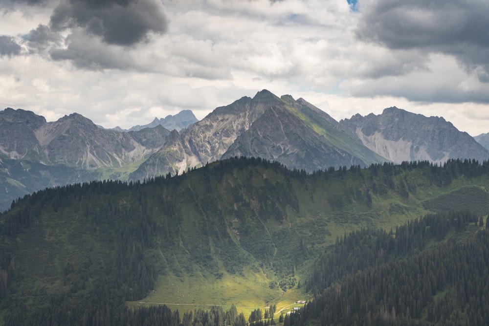 a mountain range with trees and clouds