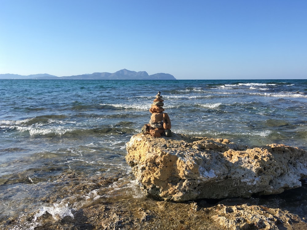 a person sitting on a rock in the water