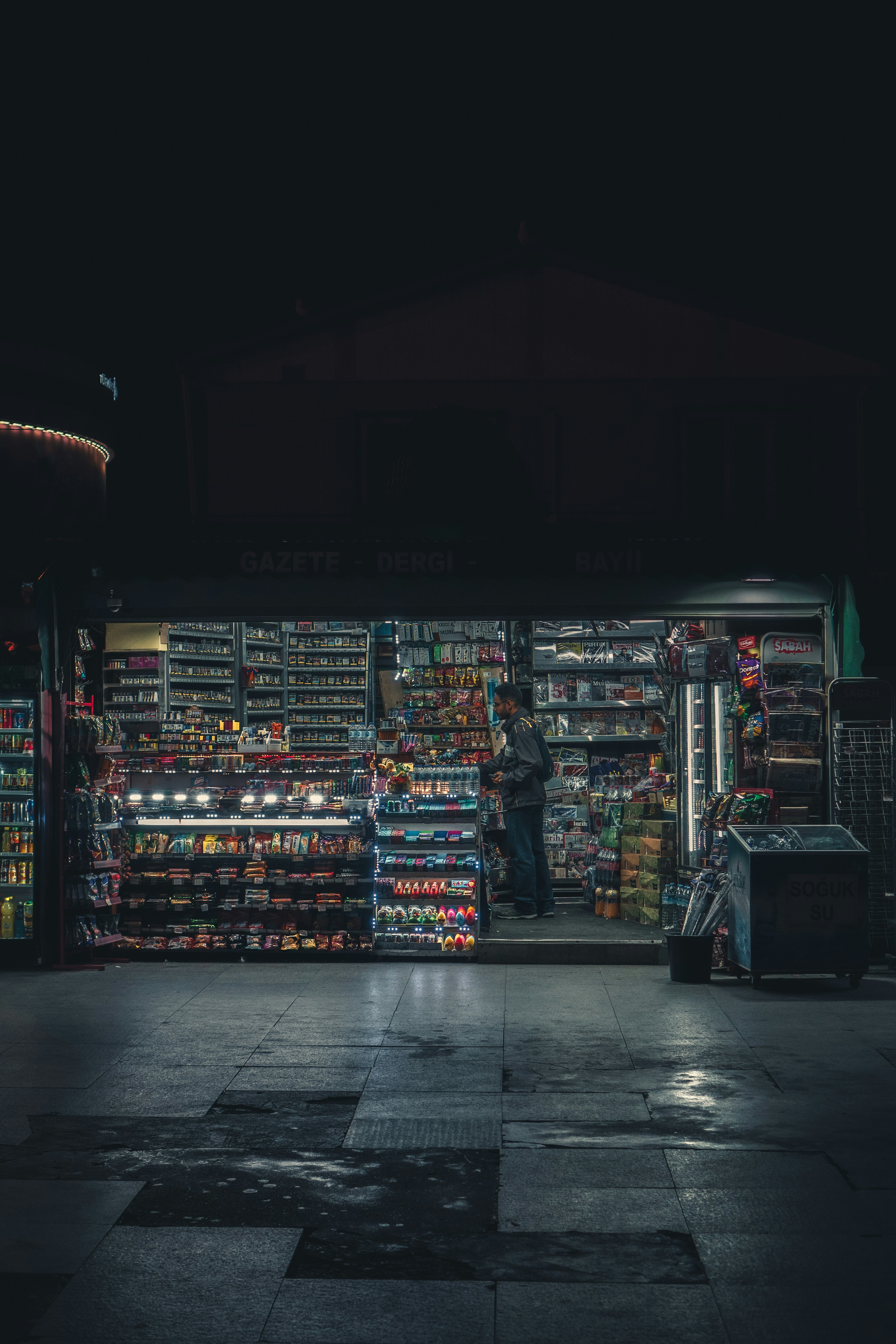 a person standing in front of a store with shelves of items