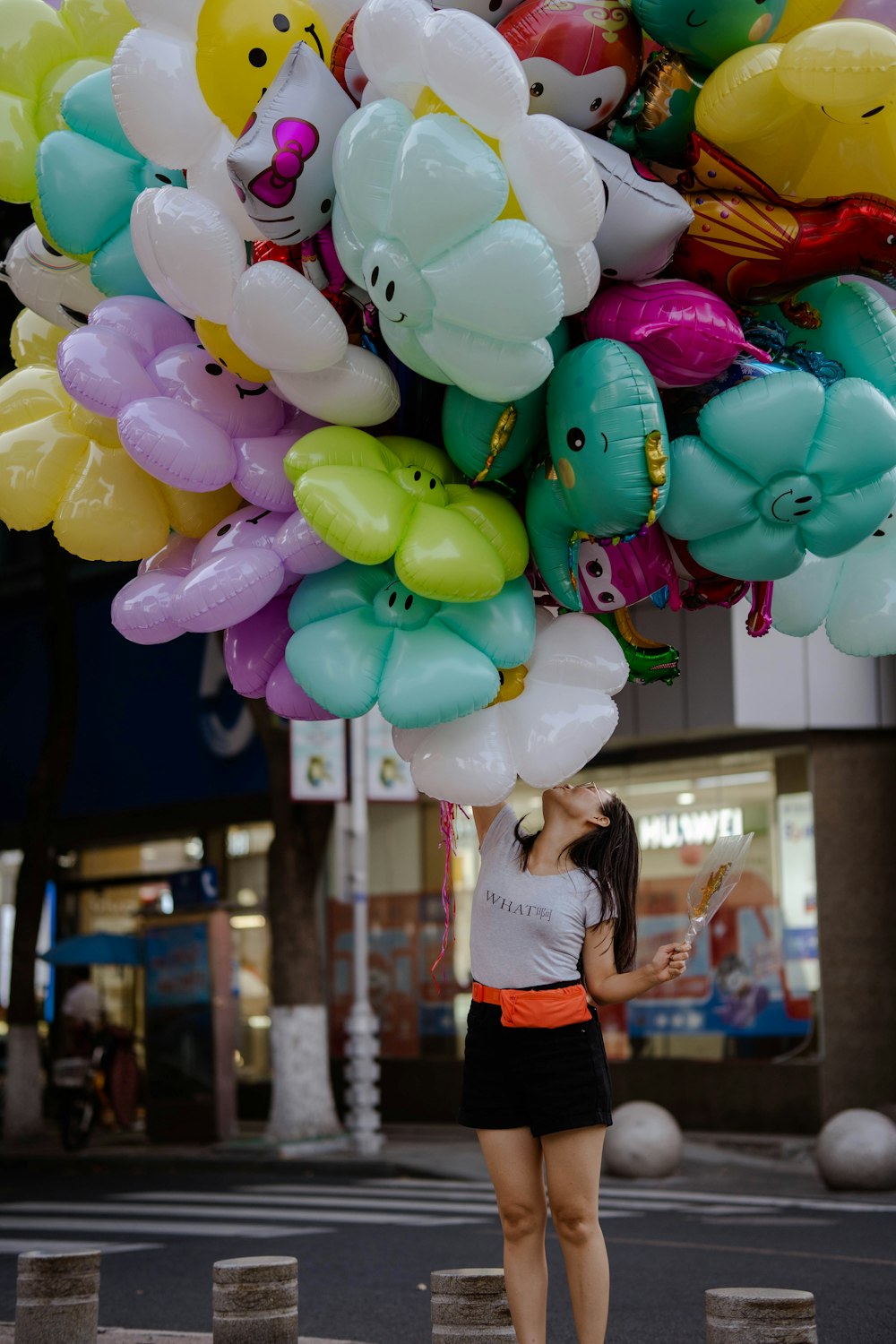 a woman holding a bunch of balloons