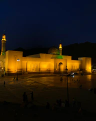 Evening exterior shot of the mosque illuminated against the Montreal skyline.