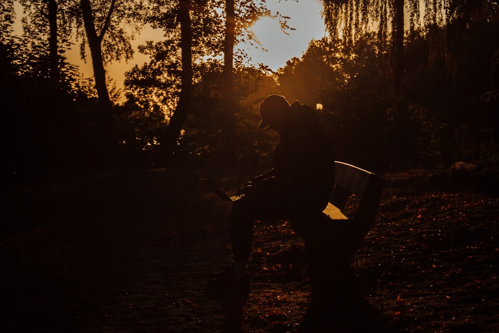 a person sitting on a bench in the woods