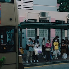 A group of diverse people waiting at a bus stop, ready to use public transport.