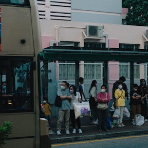 A group of diverse people waiting at a bus stop, ready to use public transport.
