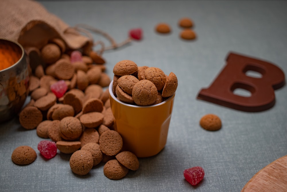 a cup of coffee with chocolate candies and a heart shaped cookie