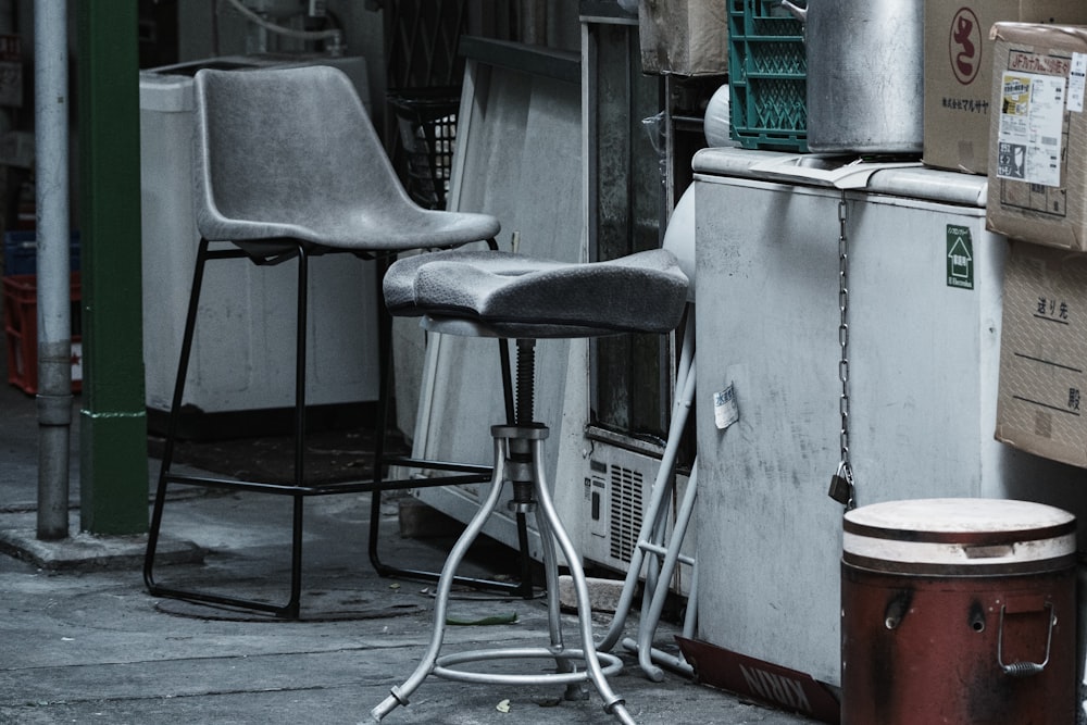 a couple of chairs next to a metal container