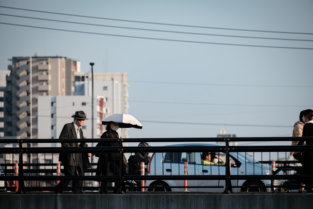 a couple of people stand under an umbrella