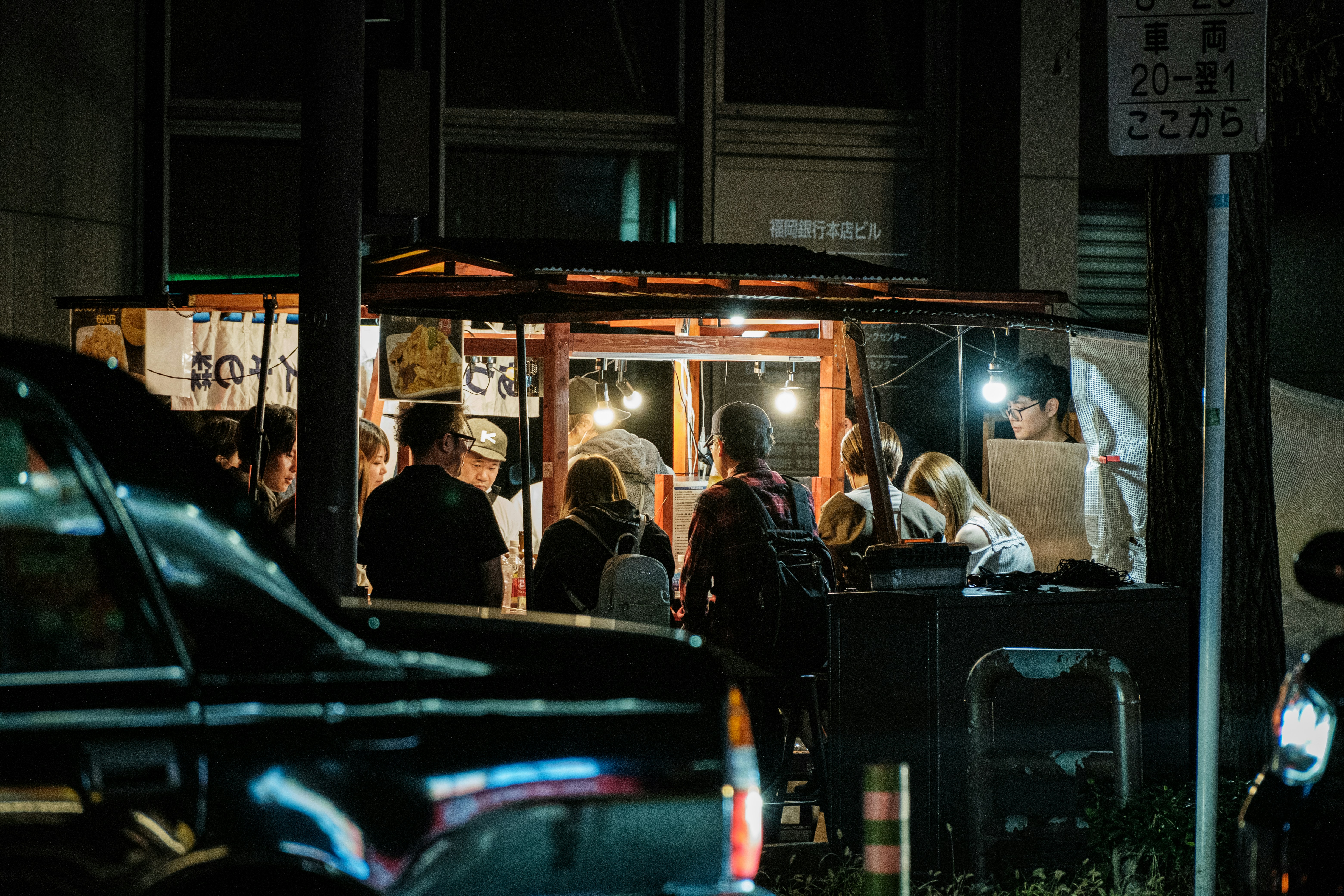 a group of people stand outside a food truck, 