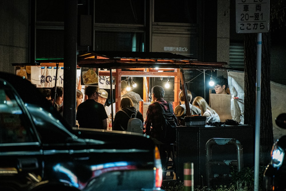 a group of people stand outside a food truck