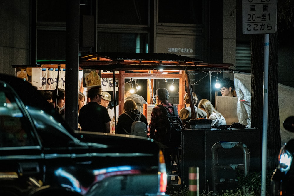 Un grupo de personas se para afuera de un camión de comida