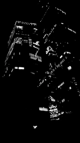 High-contrast cityscape at night with neon lights and moving shadows.