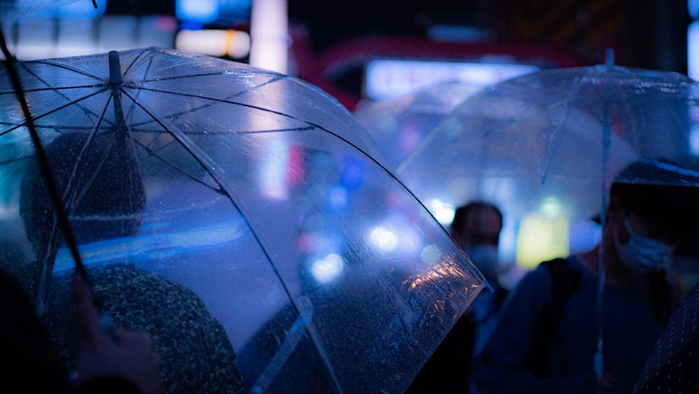 people holding umbrellas in the rain