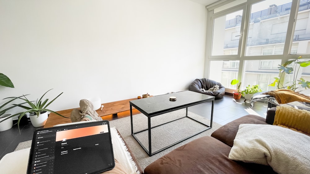 a living room with a laptop and plants