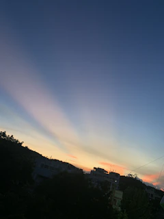 A serene Jaipur skyline at sunset with soft blue and green hues reflecting the brand's color palette.