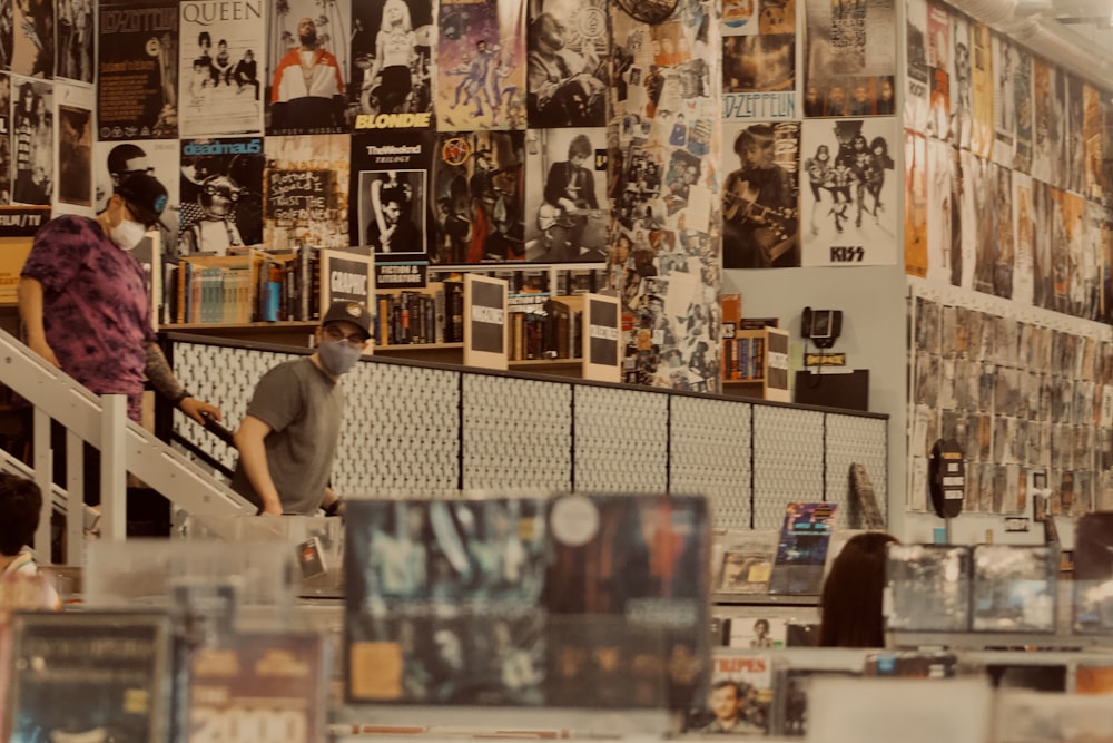 a man and woman in a room with posters on the wall