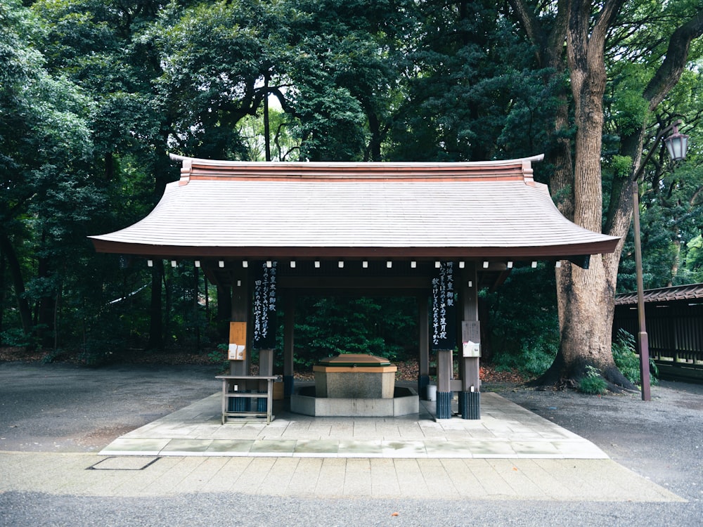 ein kleines Gebäude mit einem Schild davor mit dem Meiji-Schrein im Hintergrund