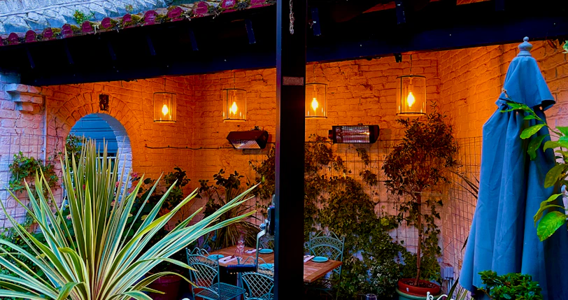 An inviting garden patio with potted plants and soft lighting at dusk.