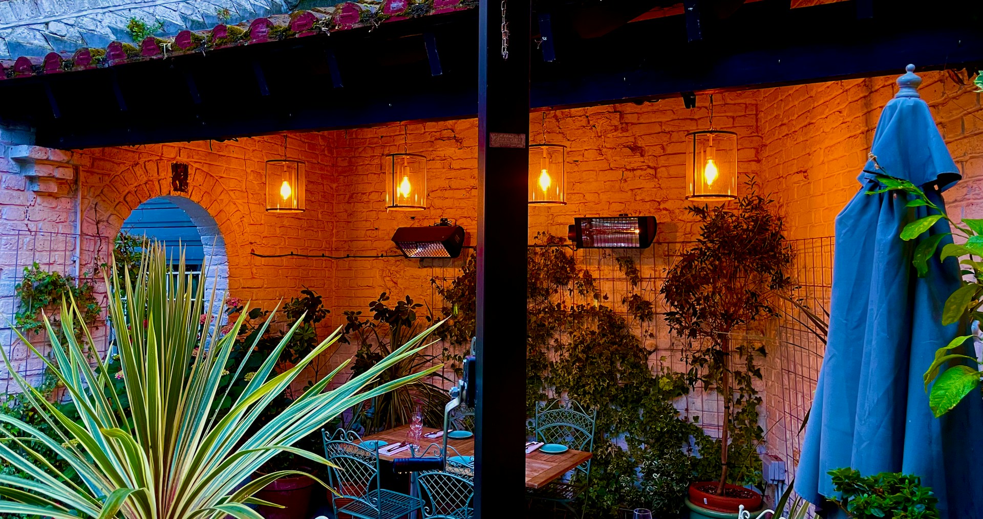 An intimate patio space featuring wooden furniture and warm garden lights blending natural materials with serene design.