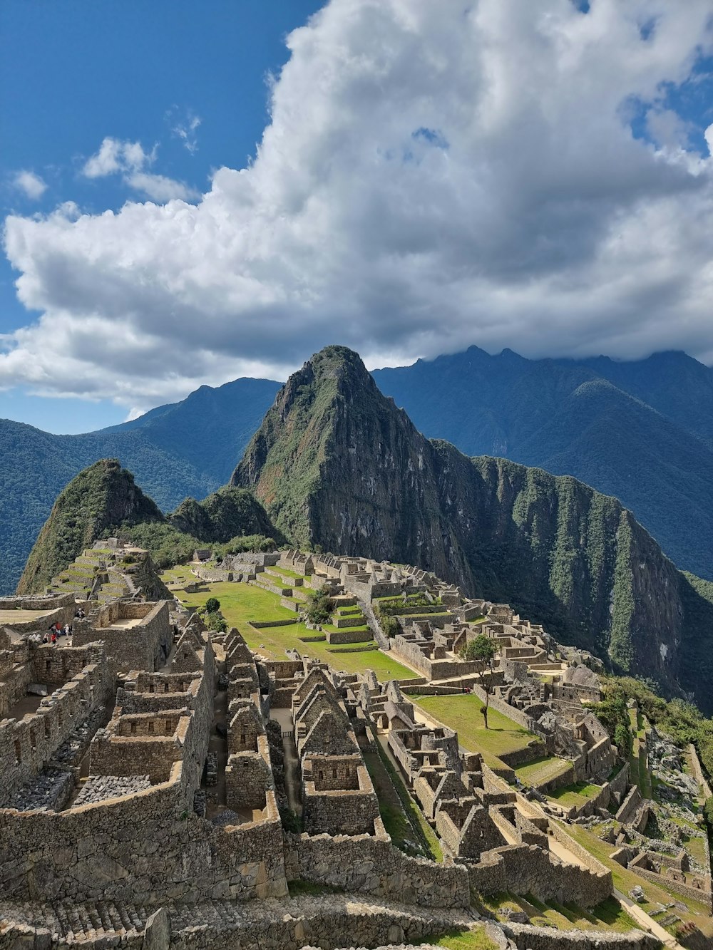 a large stone structure with steps on it and mountains in the background with Machu Picchu in the background