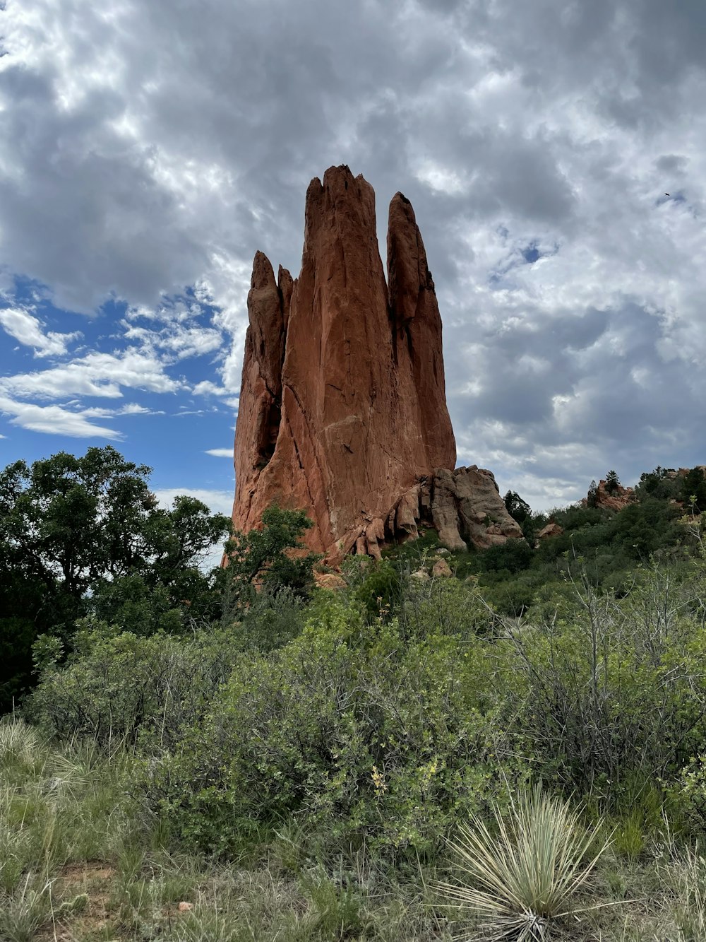 a tall rock formation in a grassy area