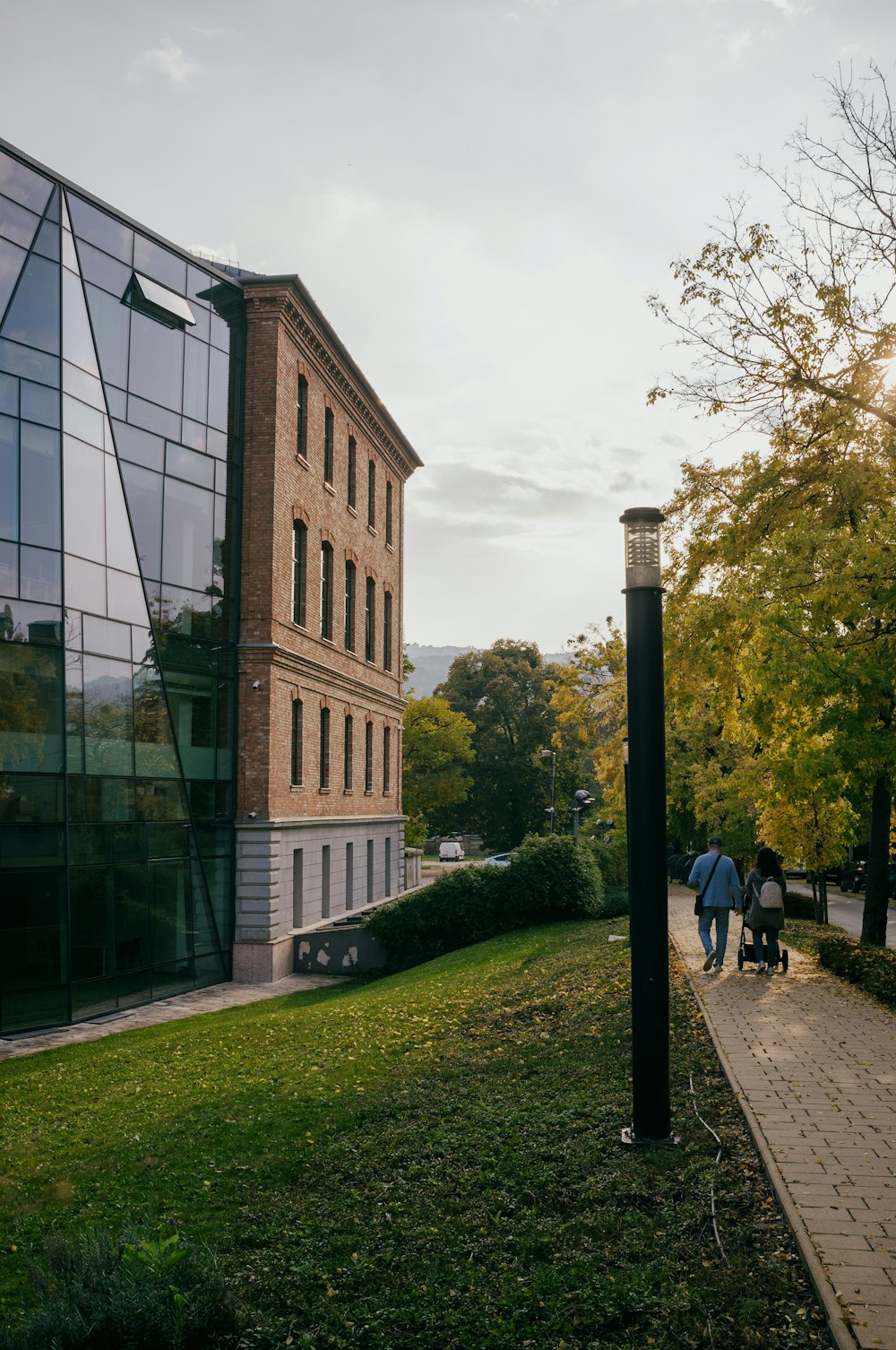 un bâtiment en brique avec une passerelle, de l’herbe et des arbres