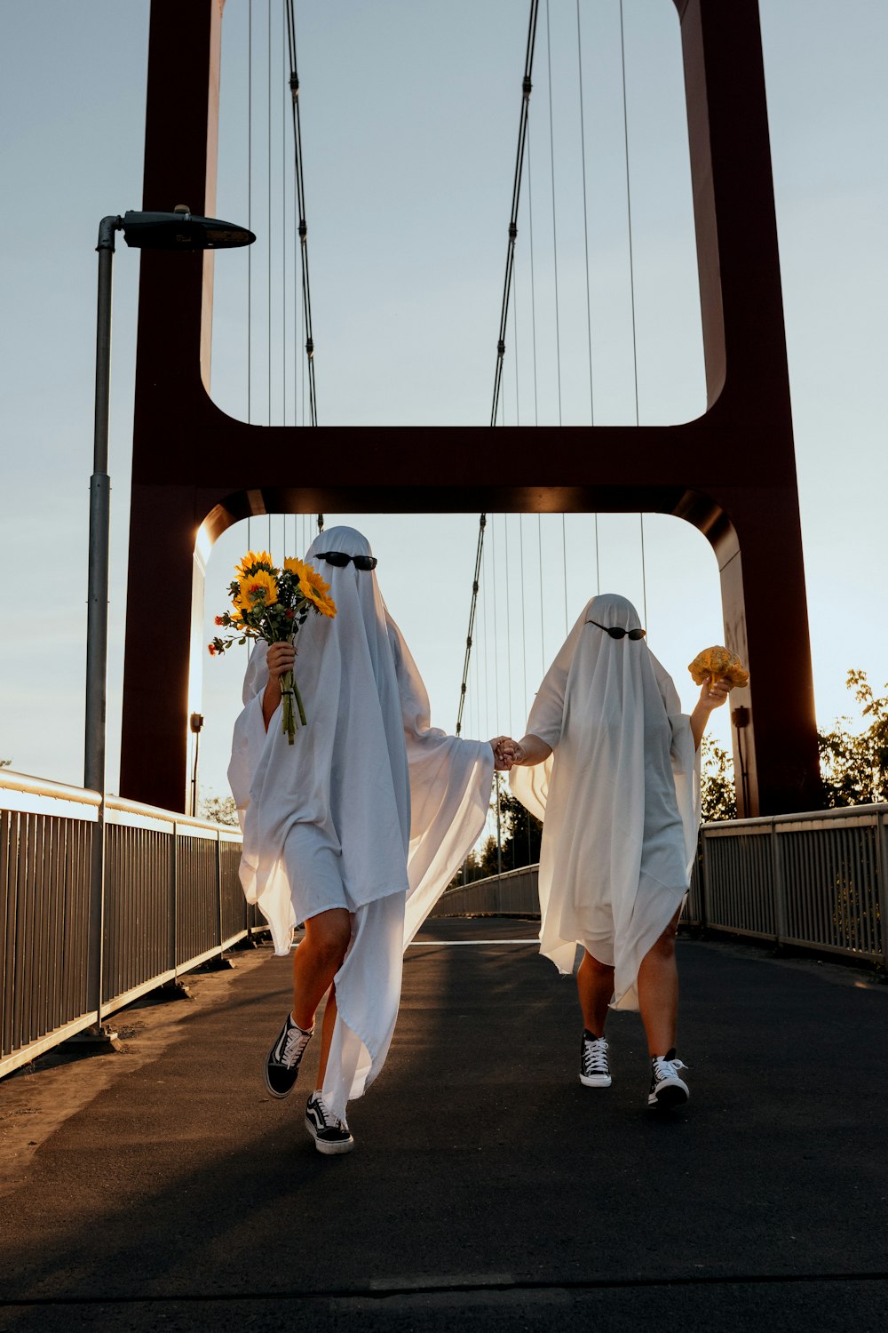 two people wearing white robes and holding flowers