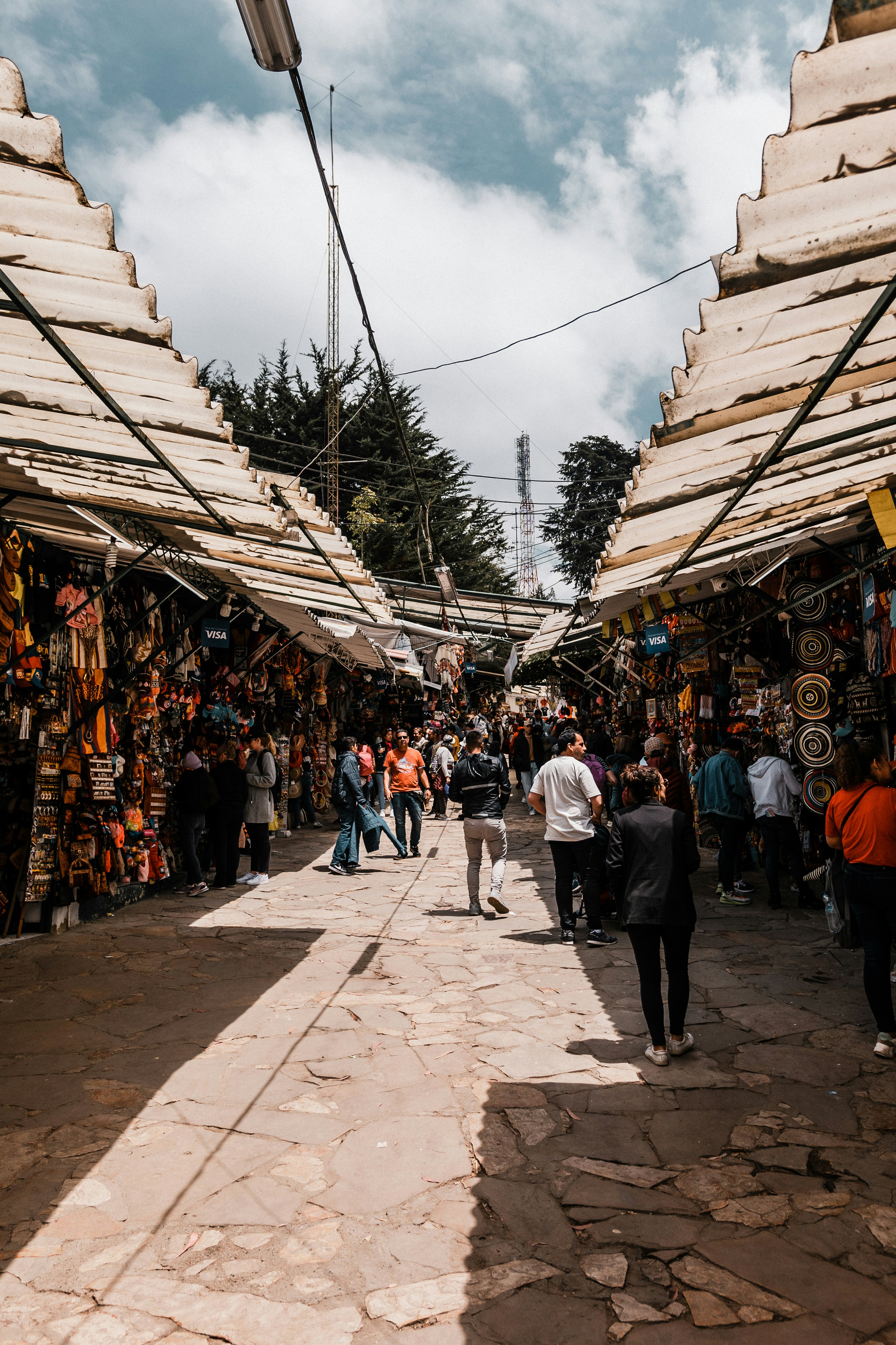 a group of people walking around a street with buildings on both sides