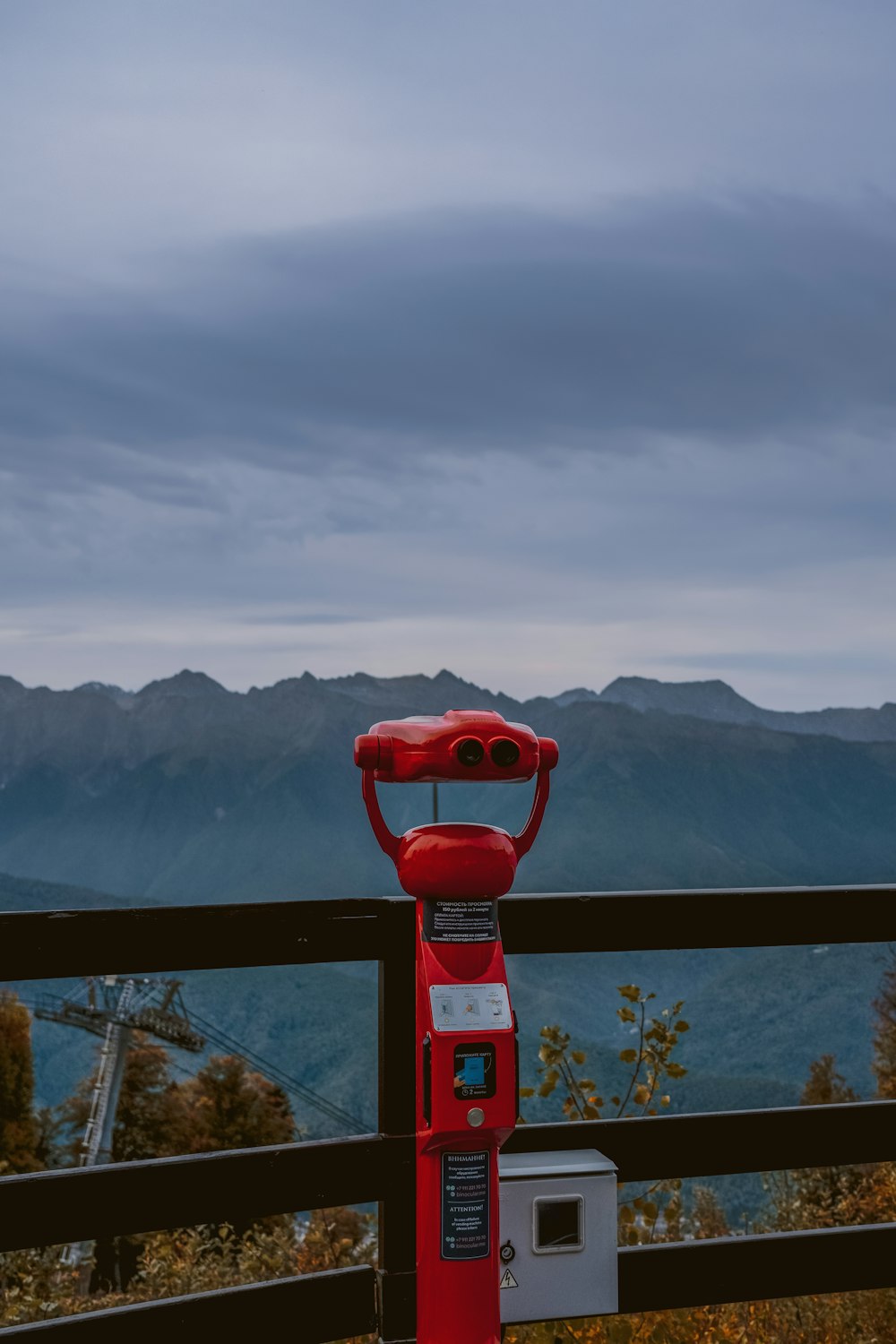 a red fire hydrant on a balcony overlooking a mountain range