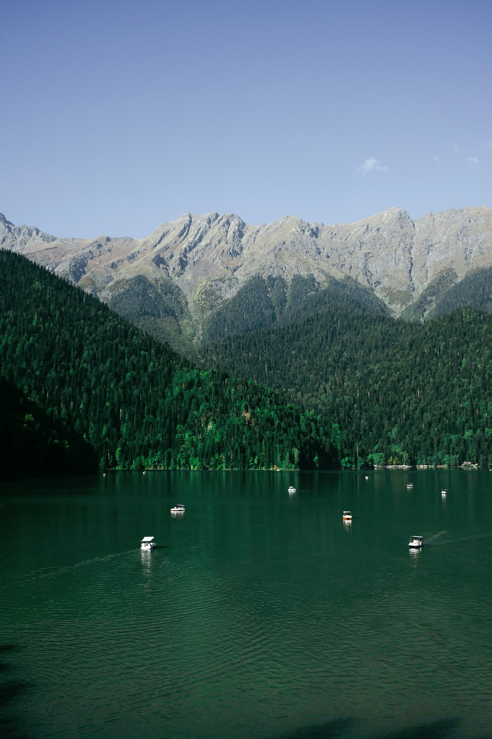 a lake with boats and mountains in the background