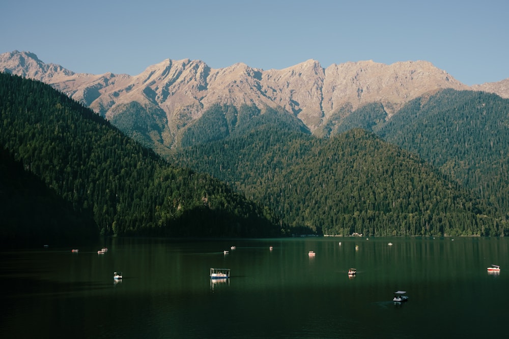 a lake with boats and mountains in the background