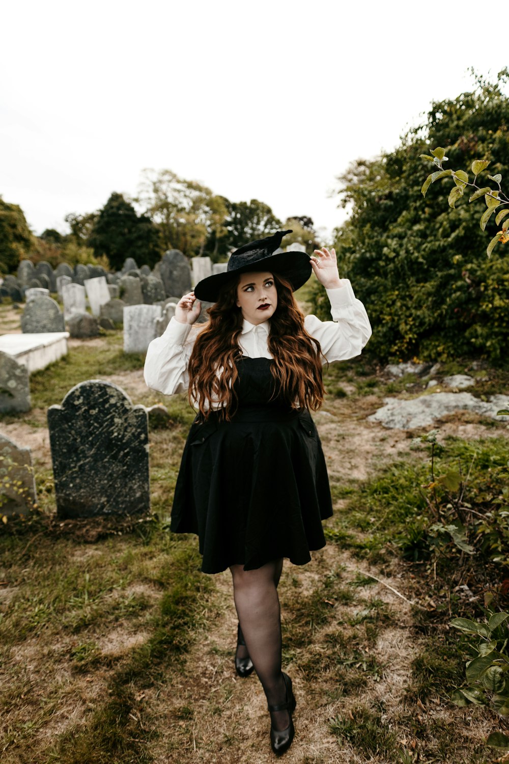 a woman wearing a hat and standing outside