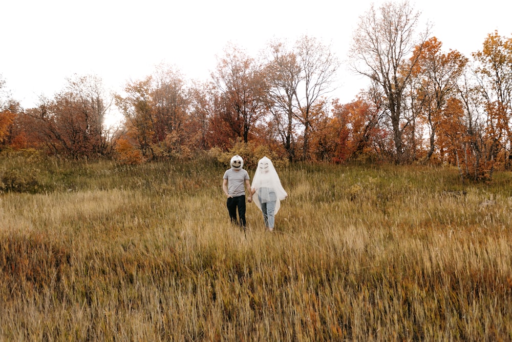 a person and a child walking through a field of tall grass