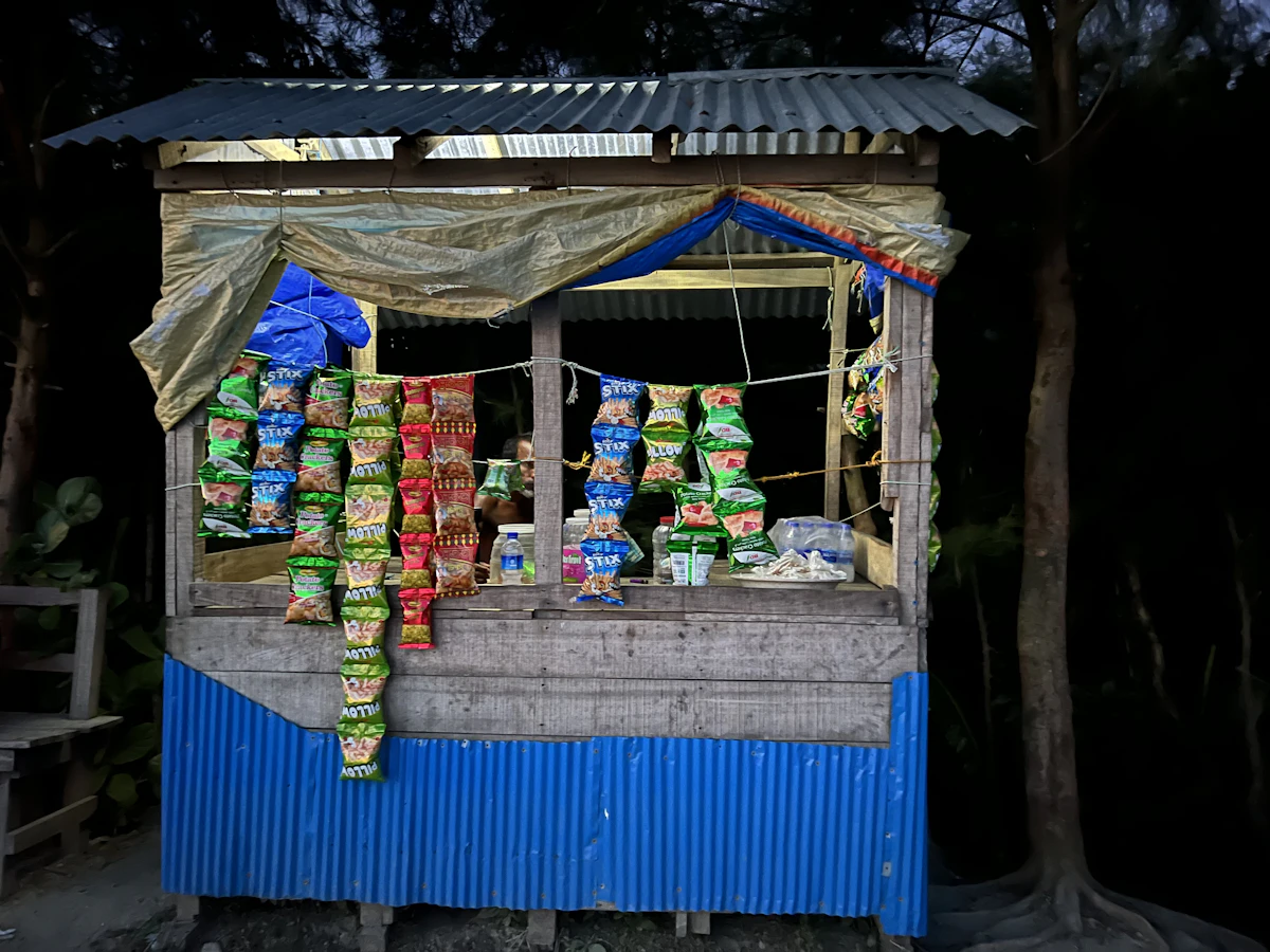 Warung kecil dengan kanopi biru di tepi pantai