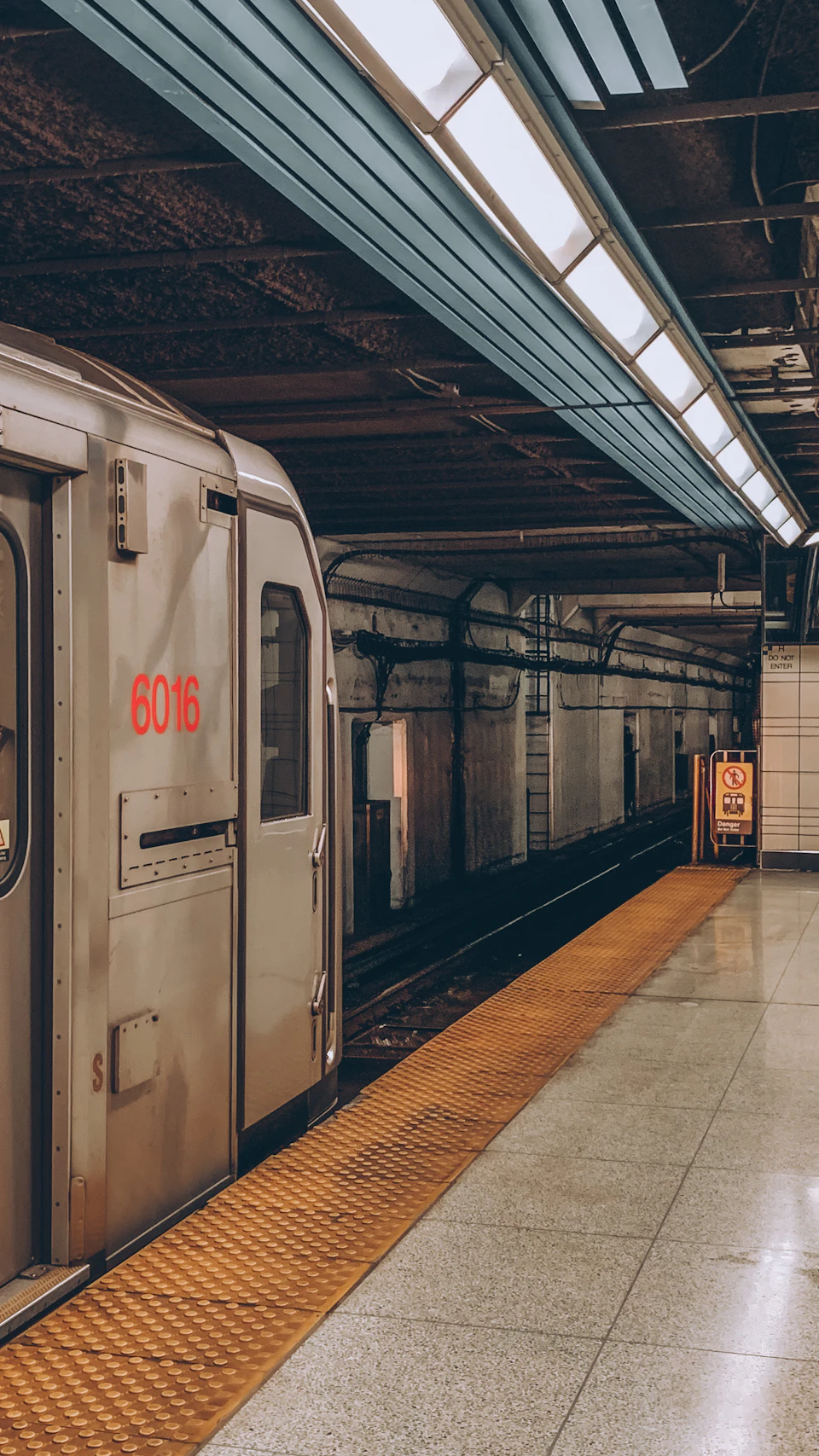 Silver train car 6016 parked on tracks with destination "6016" displayed prominently