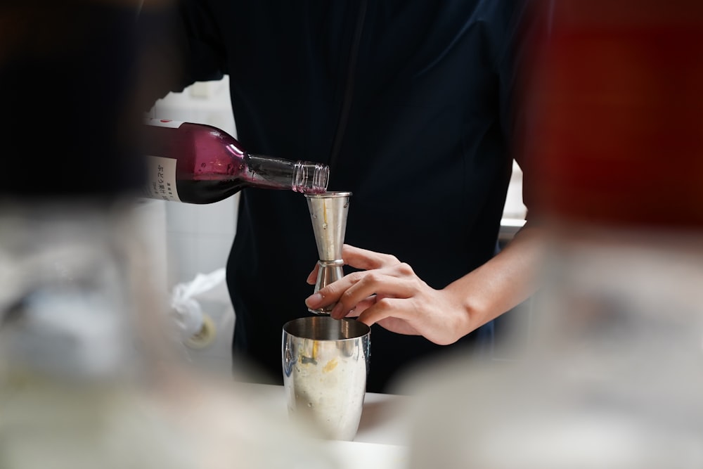 a person pouring a glass of wine